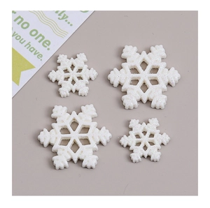 Macro shot of white glittered snowflake resin accessories for creative DIY crafts set of 4