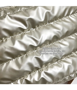 Macro shot of silver metallic quilted fabric with horizontal stitching for puffer tote bags