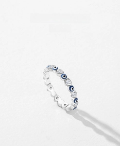 Detailed macro of S925 silver ring featuring blue enamel evil eye and heart-shaped zircon