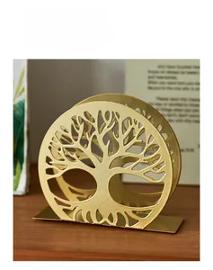 Detail of golden metal napkin holder with tree of life design on a wooden table
