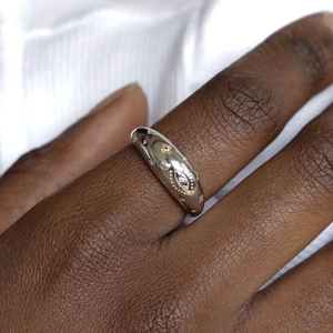 Silver star moon ring with orange zircon stone on model hand with blurred white background