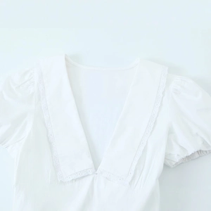 Elegante abito in popeline bianco con scollo a V, bordo in pizzo e maniche a sbuffo
