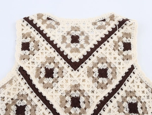 Close-up of bohemian crochet knit vest with geometric patterns in cream and coffee tones