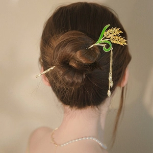 Detail einer goldenen Maiglöckchen-Haarnadel mit Emaille und fließenden Quasten