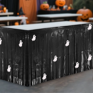 Black Halloween fringe table skirt with white ghost cutouts for spooky party decor