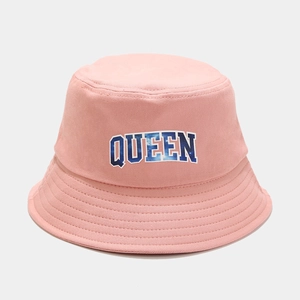 Detailed view of pink bucket hat featuring blue starry QUEEN letter embroidery
