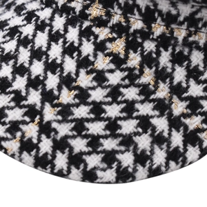 Detail of plaid octagonal hat featuring black and white pattern with gold glitter silk