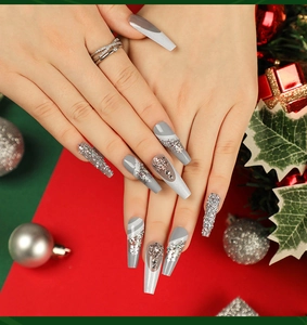 Détail de faux ongles ballerine avec paillettes argentées, flocons et strass de Noël