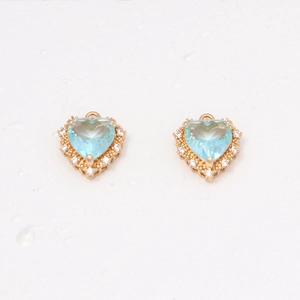 Detail of light blue heart-shaped copper pendants with pavé zircon stones and gold plating