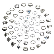Variety of silver-colored vintage and gemstone rings arranged in a large circular display