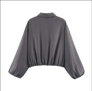 Vue arrière d'une veste courte grise avec ourlet élastique et manches longues