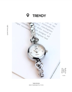 Detailed view of silver quartz watch with heart-shaped links and rhinestone accents