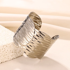 Close-up of a wide stainless steel cuff bracelet with a unique hammered texture