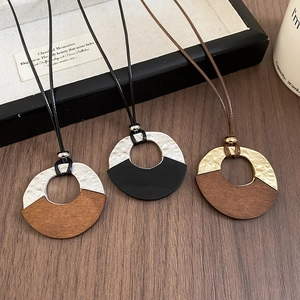 Close-up of geometric wood and hammered metal pendant with vintage wax cord