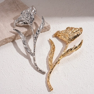 Chic metallic pleated flower brooches in gold and silver finish on a textured background