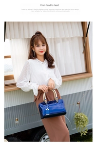 Close-up of deep blue patent leather handbag with elegant golden woven handle detail