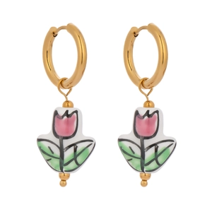 Detail of vintage gold hoops with handcrafted tulip ceramic pendants on white background