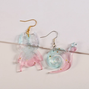 Detail of creative beetle and snail drop earrings with pink blue gradient and gold glitter