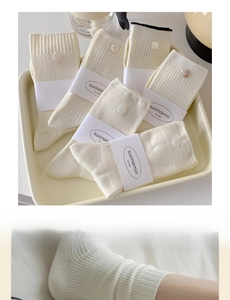 Detail view of six off-white cotton socks featuring ribbed, flat, and textured weaving styles