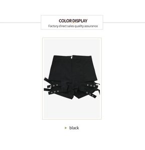 Dettaglio degli hot pants punk neri in tessuto elastico con cinturini e occhielli in metallo