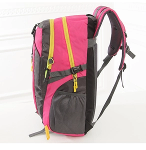 Detail of rose red hiking backpack with yellow zippers and waterproof nylon texture