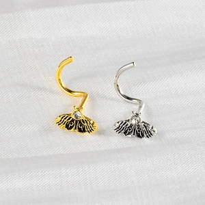 Detail of moth and butterfly nose screws in gold and silver with sparkling zircon stones