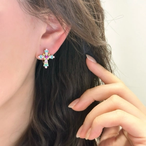 Colorful rhinestone cross hoop earrings for women shown worn on a model's ear
