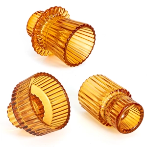 European minimalist amber ribbed glass candle holder set on a white background