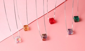 Detailed close-up of multiple colorful sugar cube crystal pendants on silver box chains