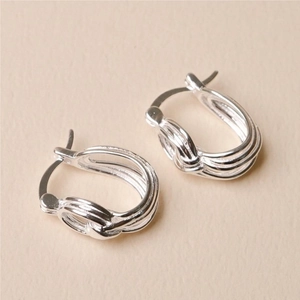 Detailed macro view of 925 sterling silver stud earrings with a twisted knot texture