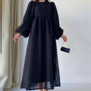 Detailed texture of black long sleeve dress with unique bubble bubble fabric and puffed sleeves