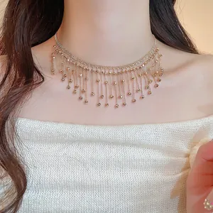Elegant gold beaded tassel necklace jewelry set worn by a model on a warm background