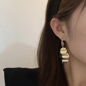 Detail of vintage gold and black disc tassel earrings showing elegant cascading texture