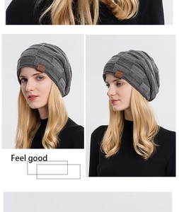 Detail of dark grey waffle knit beanie showing thick texture and brown leather patch