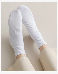 Detailed macro view of white ribbed cotton socks showing premium knit texture and elastic cuff