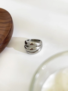 Dettaglio macro dell'anello largo multistrato ondulato in acciaio inossidabile lucido