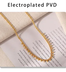 Detail of PVD gold plated necklace featuring beads and sparkling rhinestone charms