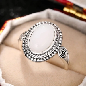 Nahaufnahme von Vintage-Silberring mit ovalem Mondstein und spiralförmigen Gravuren