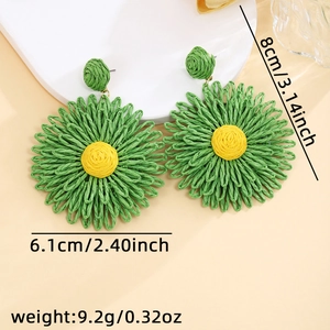 Detail shot of handmade raffia daisy earrings showing dimensions 8cm by 6.1cm