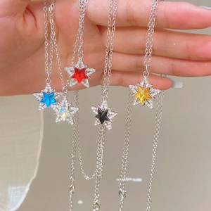 Detalle de cinco collares de copo de nieve estrella en rojo azul blanco negro y amarillo