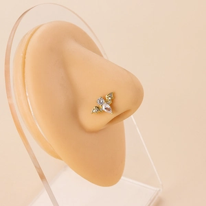 Detailed view of a gold bat nose stud with clear zircons on a silicone nose model