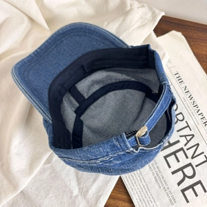Detailed interior construction and texture of a vintage washed denim baseball cap