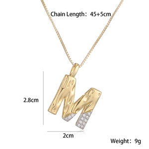 Detailed view of gold letter M pendant with wave texture and cubic zirconia dimensions