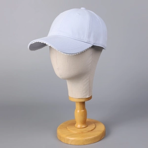 Détail d'une casquette bleue avec bordure en dentelle blanche ondulée sur la visière