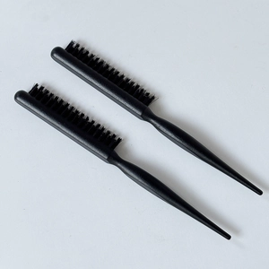 Close-up of professional black three-row teasing hairbrush with thin pointed tail handle