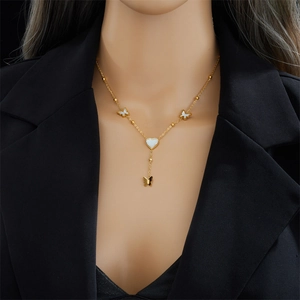 Elegant gold titanium steel necklace with white heart and butterfly pendants on a model