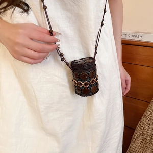 Detail view of ethnic crossbody bag with coconut shell beads and floral resin accents