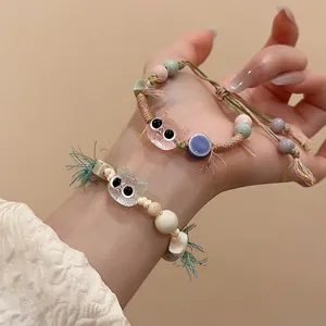Cute ceramic cat bead bracelet with colorful woven cord and tassel on wrist