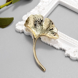 Elegant gold ginkgo leaf brooch pin with detailed texture and minimalist luxury style