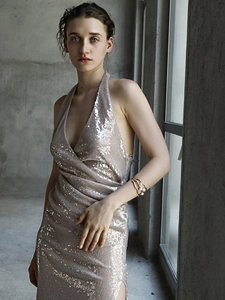 Detail of a three-layer gold-plated knotted bangle with faux pearl on a female model